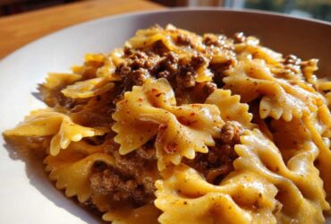Close-up of creamy parmesan garlic beef bowtie pasta coated in a rich, savory sauce.