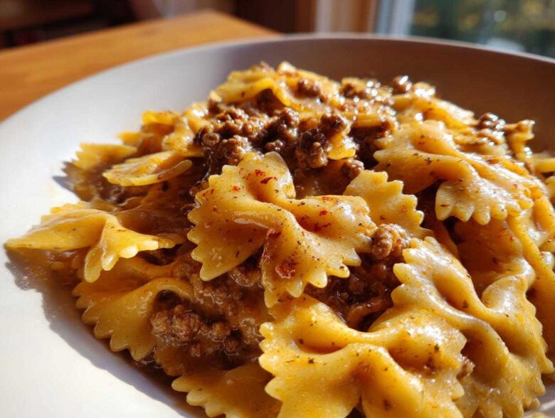 Close-up of creamy parmesan garlic beef bowtie pasta coated in a rich, savory sauce.