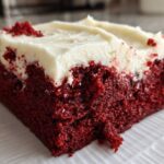 Close-up of a rich, fudgy red velvet brownies square topped with thick cream cheese frosting.