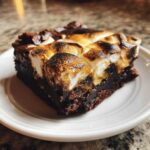 A rich, fudgy slice of hot chocolate brownies topped with perfectly toasted, slightly charred marshmallows.