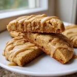 Close-up of soft, rectangular maple cookies stacked and drizzled generously with a nutty maple glaze.
