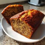 Close-up of two slices of moist mini banana bread loaves showing the dark, speckled crumb texture.