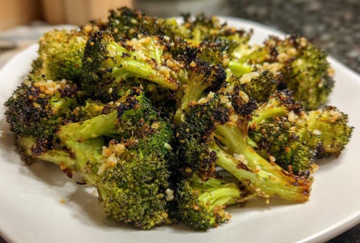 Close-up of perfectly cooked roasted broccoli florets, slightly charred and topped with garlic seasoning.