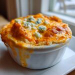 Close-up of hot, bubbling Buffalo chicken dip topped with melted cheddar and blue cheese crumbles.