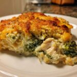 A close-up slice of creamy chicken broccoli rice casserole with a golden, crunchy topping.