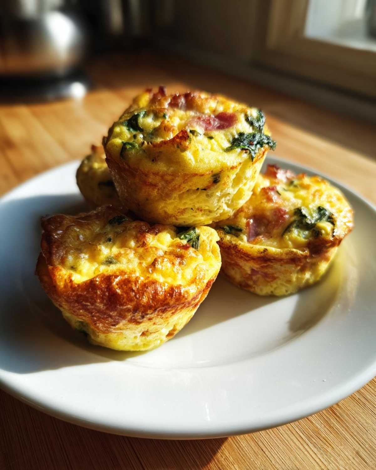 A stack of four golden brown cottage cheese egg cups starbucks style on a white plate.