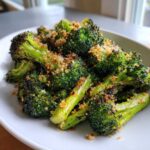 Close-up of vibrant green roasted broccoli florets topped with golden brown breadcrumbs.