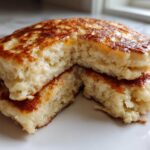 Close-up of fluffy coconut flour pancakes stacked and cut open to show the texture.