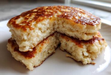 Close-up of fluffy coconut flour pancakes stacked and cut open to show the texture.