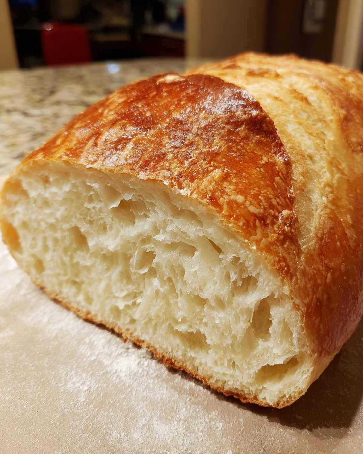 Close-up of the airy, open crumb texture inside a freshly baked Italian bread loaf.