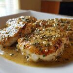 Four golden-brown chicken breasts smothered in a creamy, herb-flecked sauce, representing delicious Marry Me Chicken.