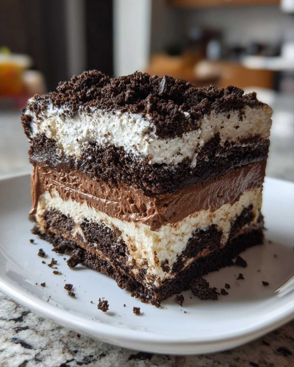 A rich, layered slice of oreo dirt cake featuring chocolate pudding, cream filling, and cookie crumbs.