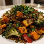 Close-up of a vibrant veggie lentil salad featuring brown lentils, roasted orange squash cubes, and broccoli florets.