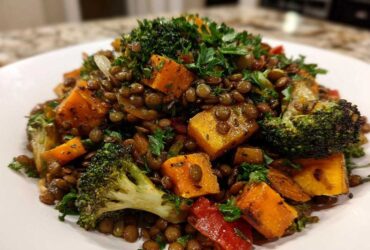 Close-up of a vibrant veggie lentil salad featuring brown lentils, roasted orange squash cubes, and broccoli florets.