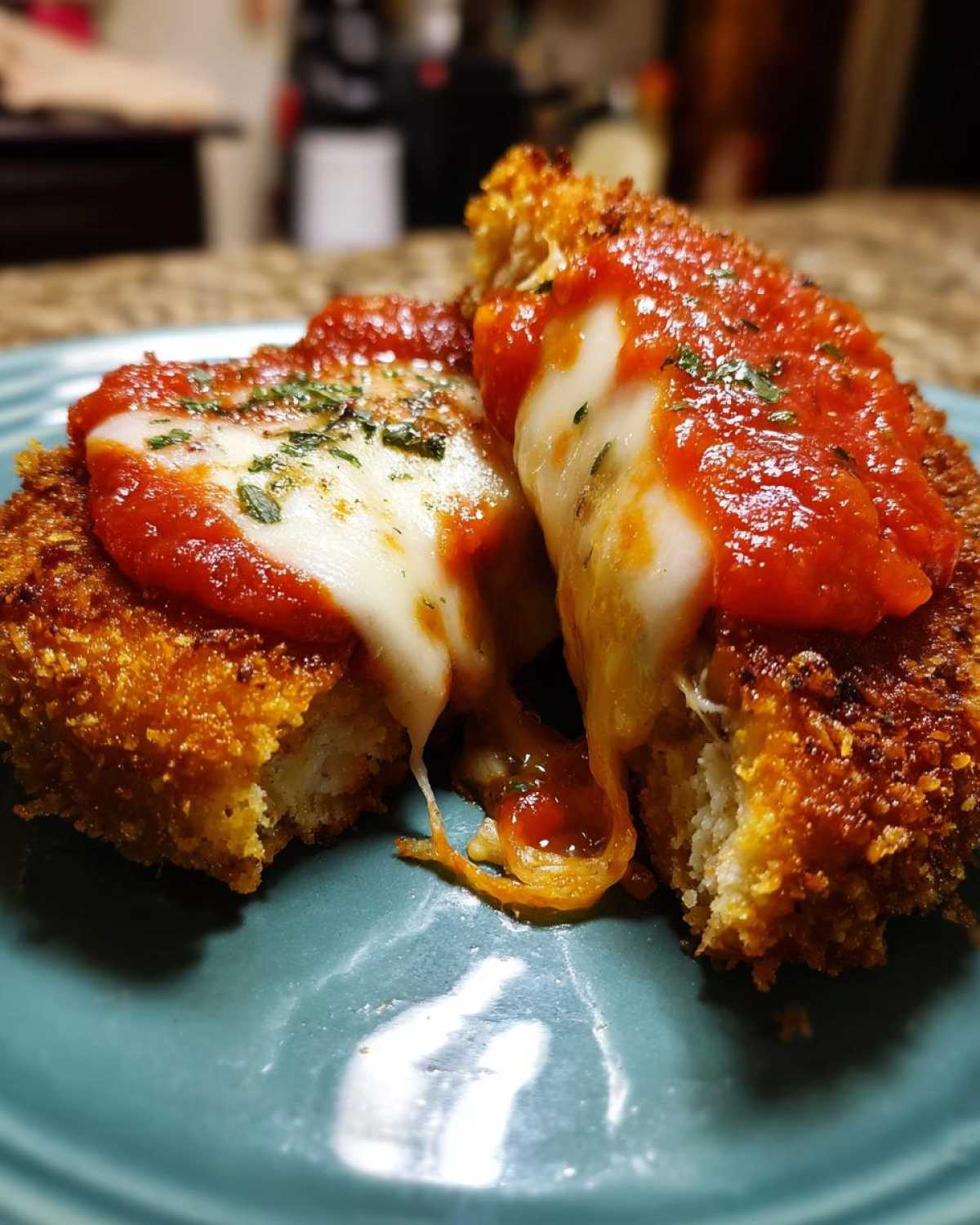 Close-up of Air Fryer Chicken Parmesan cut open showing gooey, melted mozzarella cheese and marinara sauce.