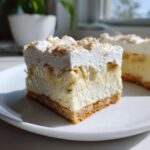 A thick square slice of Banana Pudding Cheesecake Bars showing graham cracker crust, creamy filling with bananas, and whipped topping.