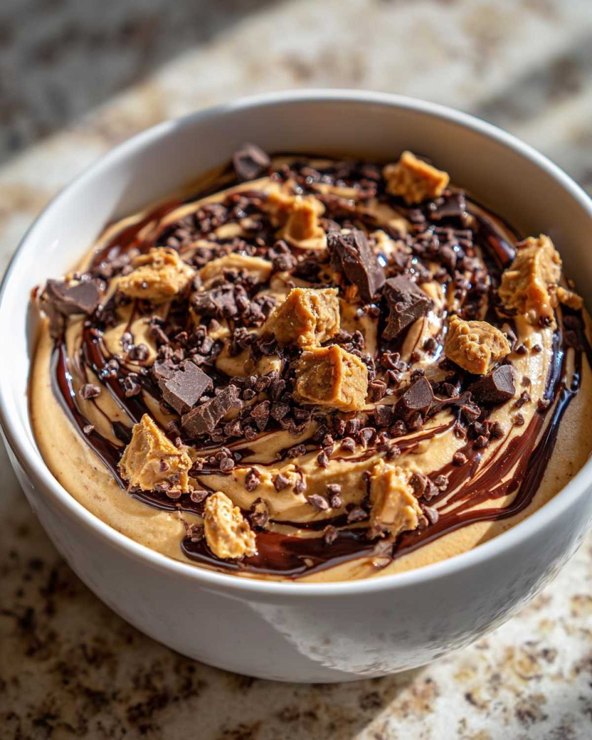 Close-up of Chocolate Peanut Butter Cheesecake Dip topped with chocolate chips and peanut butter chunks.