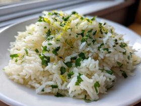 A mound of fluffy white Cilantro Lime Rice topped with chopped cilantro and bright yellow lime zest.