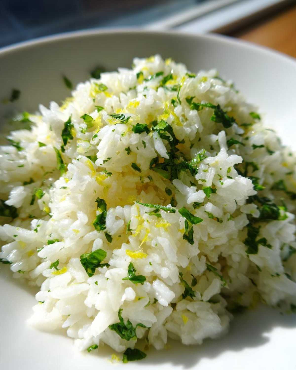 Close-up of fluffy Cilantro Lime Rice mixed with chopped cilantro and bright yellow lime zest.