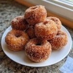 A stack of freshly made Cinnamon Sugar Air Fryer Donuts generously coated in sparkling sugar.