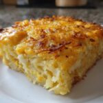 A close-up of a square slice of Copycat Cracker Barrel Hashbrown Casserole with a golden, cheesy, crispy top.