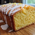 Close-up of a moist Copycat Starbucks Iced Lemon Loaf drizzled with white icing and lemon zest on top.
