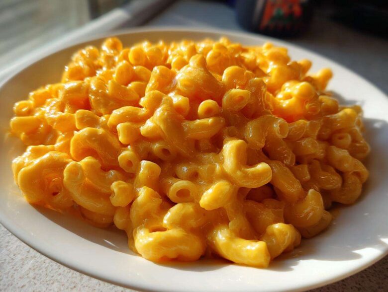 A close-up, mouthwatering serving of creamy Instant Pot Mac and Cheese featuring elbow macaroni coated in bright orange cheese sauce.