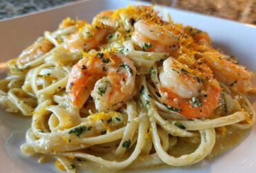 Close-up of a serving of Creamy Lemon Garlic Shrimp Pasta topped with bright shrimp and lemon zest.