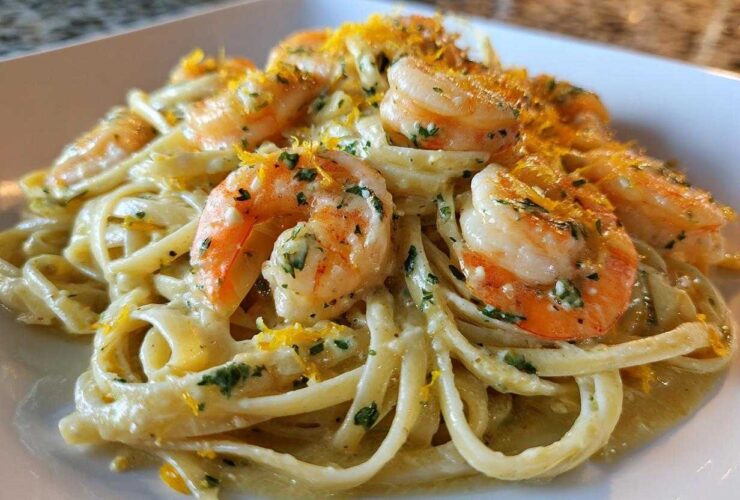 Close-up of a serving of Creamy Lemon Garlic Shrimp Pasta topped with bright shrimp and lemon zest.