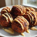 A plate of golden brown, crispy air fryer falafel drizzled generously with creamy tahini sauce.