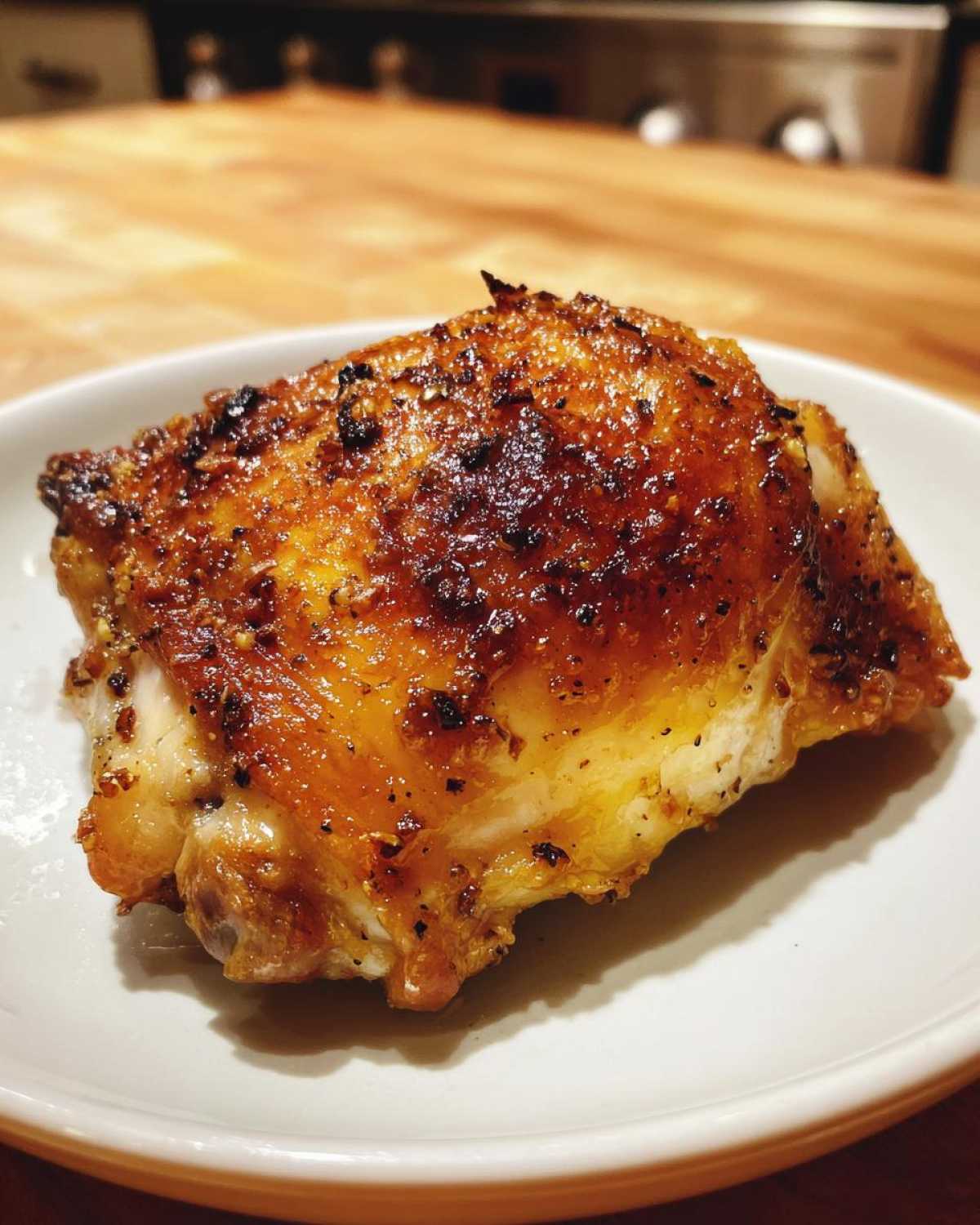 Close-up of a perfectly roasted Lemon Garlic Roasted Chicken Thighs with crispy, golden-brown skin.