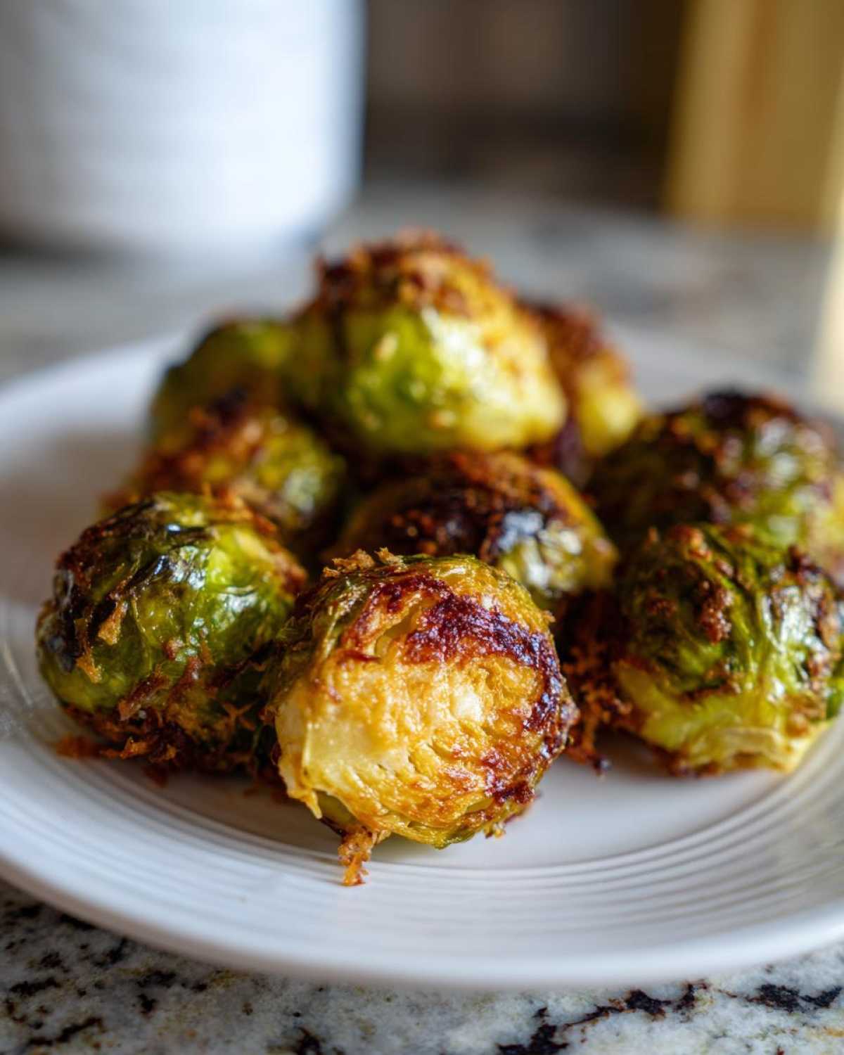 Close-up of roasted Brussels sprouts coated in golden, crispy Parmesan cheese, ready to eat.