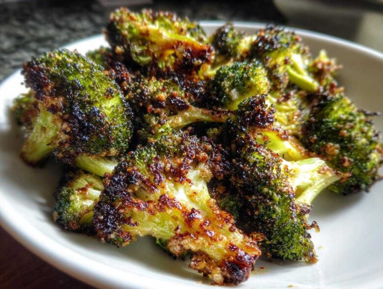 Close-up of perfectly cooked Crispy Parmesan Roasted Broccoli with dark, caramelized edges.