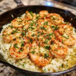 Close-up of Garlic Butter Shrimp and Rice Skillet, featuring plump shrimp topped with parsley in a cast iron pan.