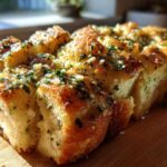 Close-up of freshly baked Garlic Parmesan Pull-Apart Bread glistening with butter and herbs.