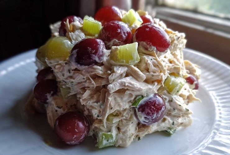A mound of creamy Honey Mustard Chicken Salad with Grapes and celery served on a white plate.