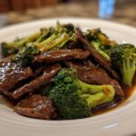 Close-up of tender slices of beef coated in savory sauce mixed with bright green broccoli florets, Instant Pot Beef and Broccoli.