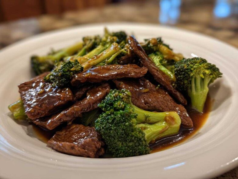 Close-up of tender slices of beef coated in savory sauce mixed with bright green broccoli florets, Instant Pot Beef and Broccoli.