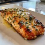 A perfectly cooked fillet of Keto Garlic Butter Salmon, glistening with melted butter and topped with fresh parsley.