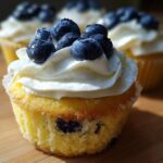Close-up of a Lemon Blueberry Cupcakes with Cream Cheese Frosting, topped with fresh blueberries.