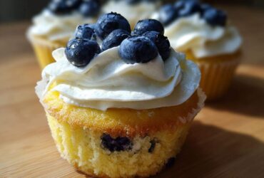 Close-up of a Lemon Blueberry Cupcakes with Cream Cheese Frosting, topped with fresh blueberries.