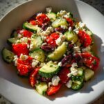 Close-up of a fresh Mediterranean Cucumber Tomato Salad with feta cheese and Kalamata olives.