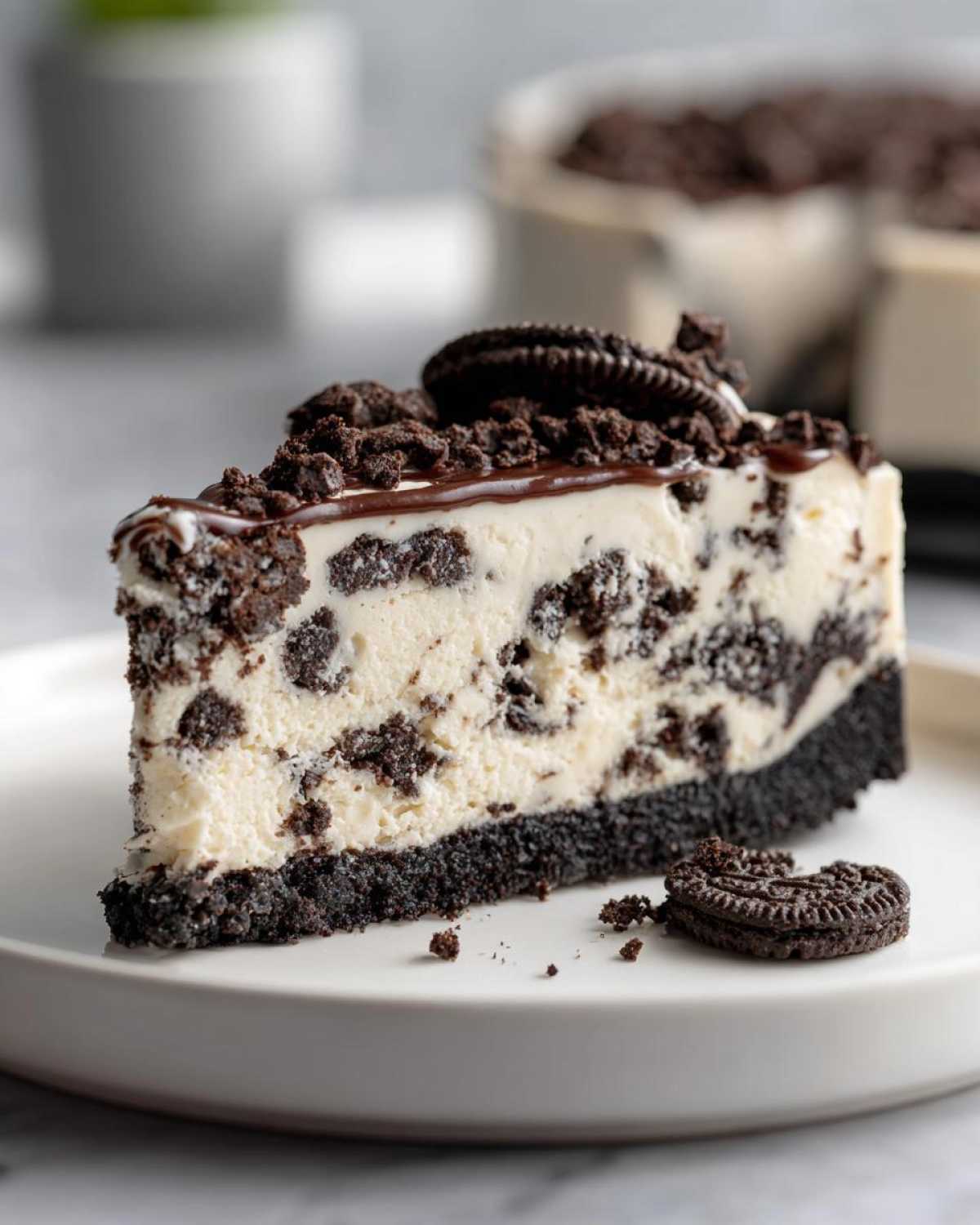 A perfect slice of No-Bake Oreo Cheesecake with a thick Oreo crust, creamy filling, and chocolate topping.