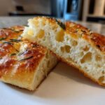 Close-up of No-Knead Skillet Focaccia with Rosemary, showing the airy, open crumb and golden crust.
