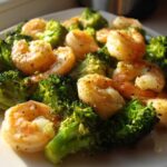 Close-up of cooked shrimp and bright green broccoli florets seasoned for Sheet Pan Garlic Butter Shrimp and Broccoli.