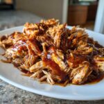 A close-up of shredded pork covered in rich sauce, ready to serve, showcasing the Slow Cooker Honey Garlic Pulled Pork.