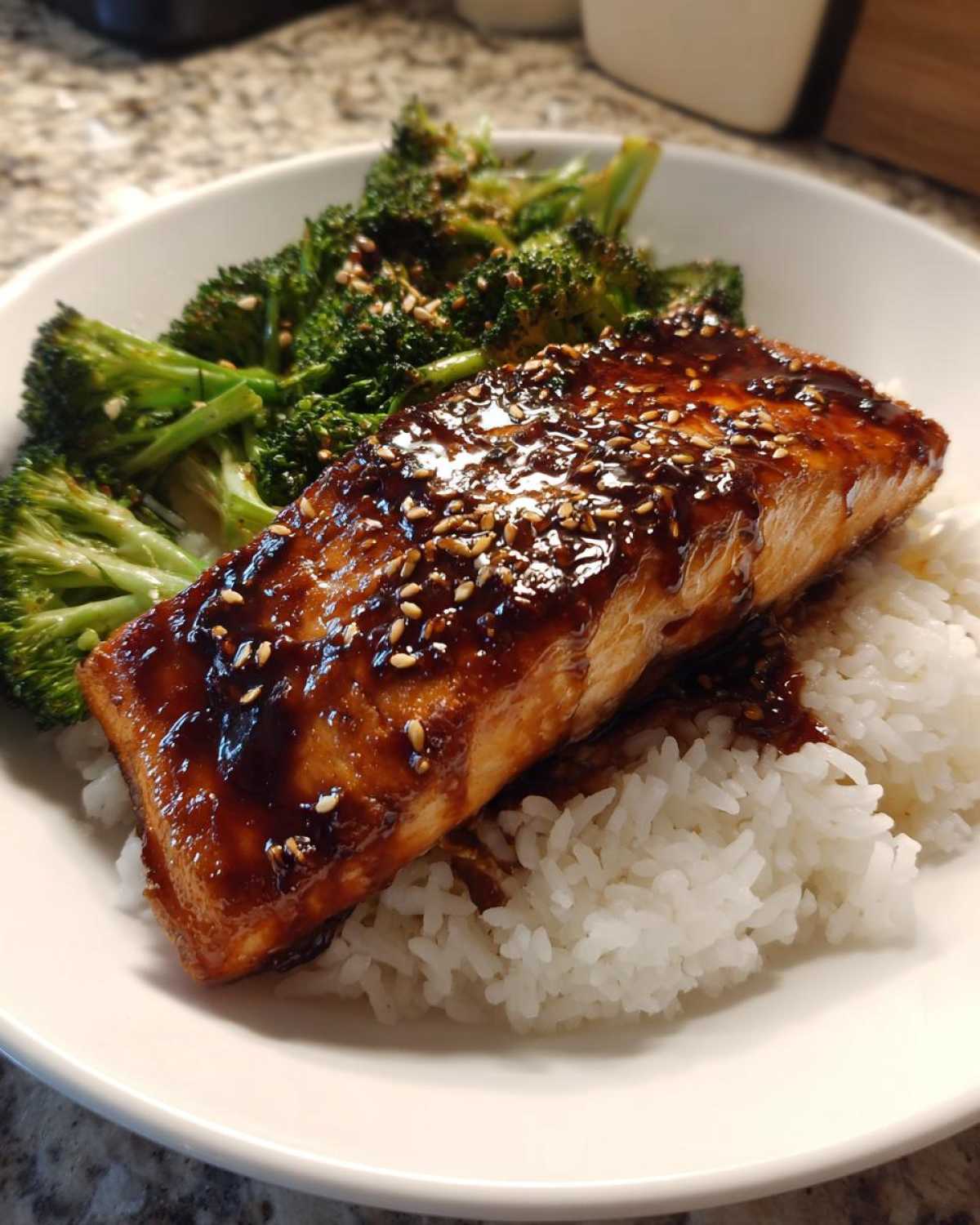 Close-up of a Teriyaki Salmon Rice Bowls serving with glazed salmon, white rice, and roasted broccoli.