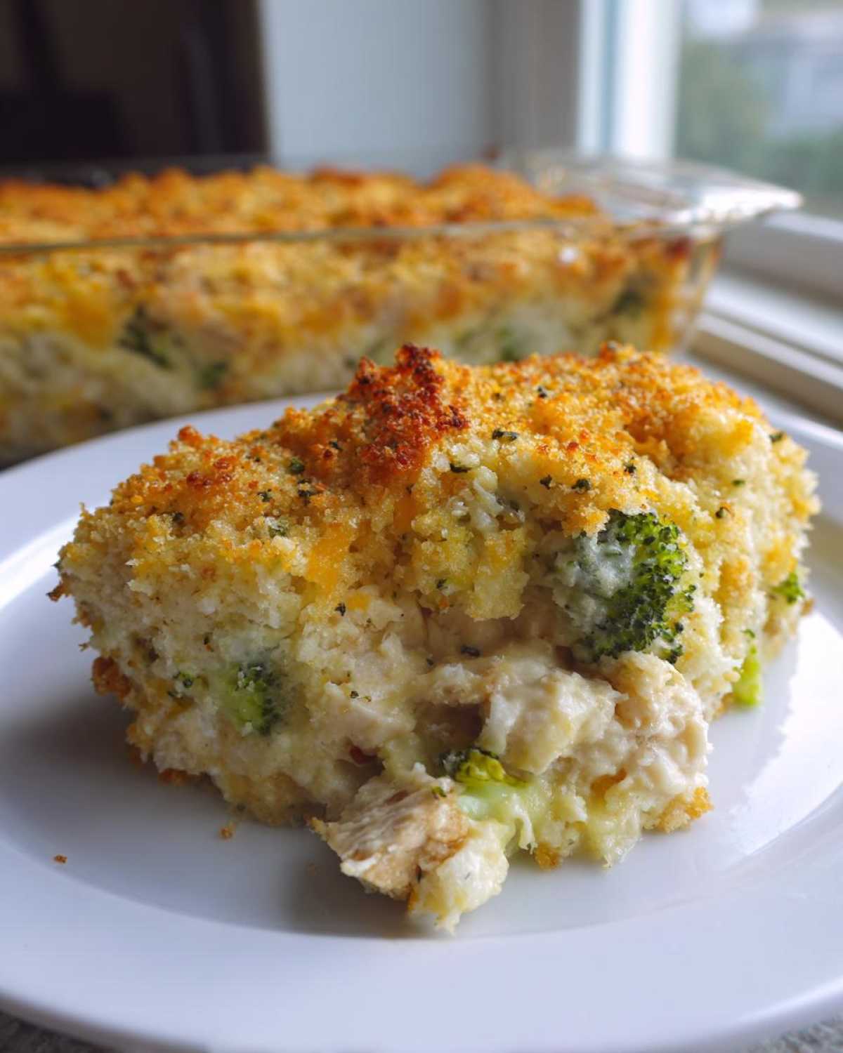 A close-up serving of Cheesy Chicken and Broccoli Bake Comfort Dish with a golden, crunchy topping.