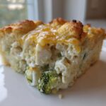A close-up of a square slice of Cheesy Chicken and Broccoli Bake Comfort Dish with a golden, cheesy crust.