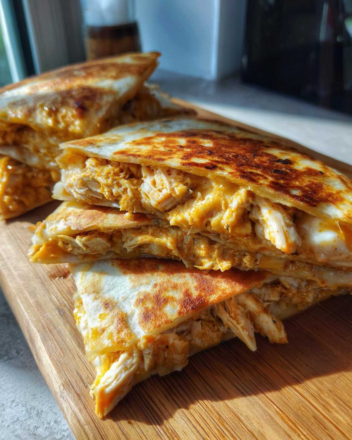 Close-up of stacked, golden-brown Cheesy Chicken Quesadilla slices revealing the creamy, shredded chicken filling.